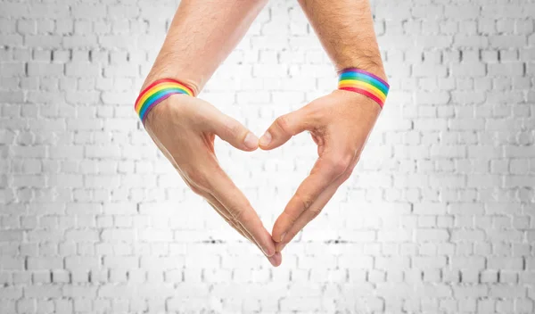 Männliche Hände mit Gay Pride Armbändern, die Herz zeigen — Stockfoto