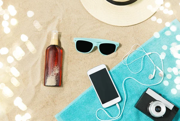 Smartphone, câmera, toalha, chapéu e tons na praia — Fotografia de Stock