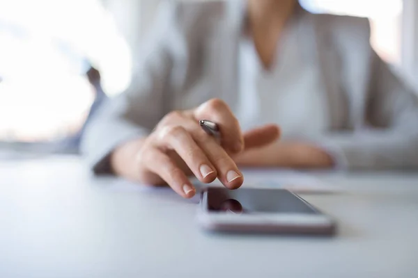 Hand der Geschäftsfrau mit Smartphone im Büro — Stockfoto