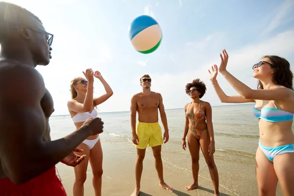 Happy vrienden spelen bal op zomer-strand — Stockfoto