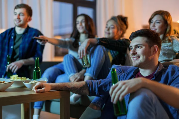 Amis heureux avec des boissons regarder la télévision à la maison — Photo