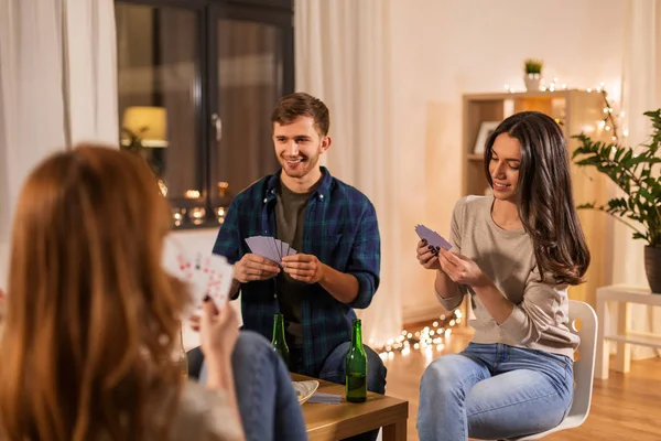 Amigos jugando cartas y bebiendo cerveza en casa — Foto de Stock