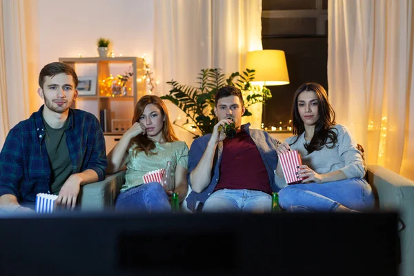 Amis avec bière et pop-corn regarder la télévision à la maison — Photo