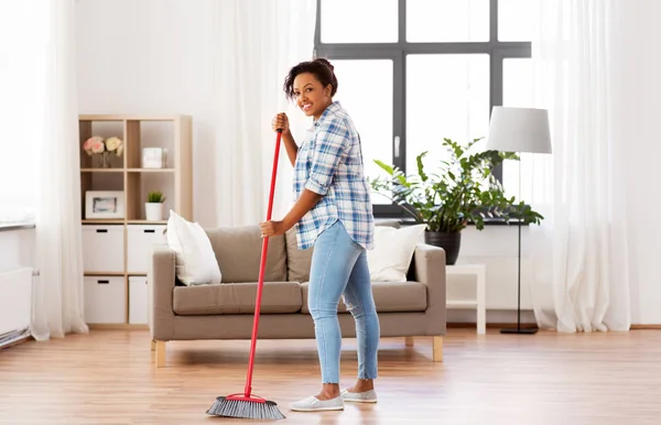 Žena se zametacím koštětem čištění podlahy — Stock fotografie