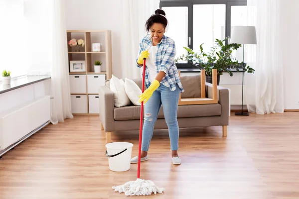 Afrikaanse vrouw of huisvrouw schoonmaken vloer thuis — Stockfoto