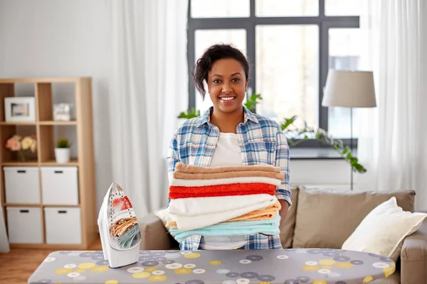 Afrikansk amerikansk kvinna med strykas linne hemma — Stockfoto