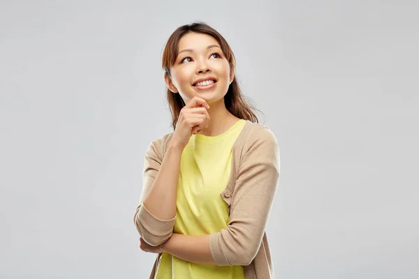 Gri arka planda mutlu Asyalı kadın — Stok fotoğraf