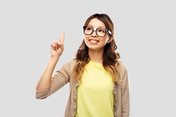 Asiatique femme dans lunettes ou étudiant avec doigt vers le haut — Photo