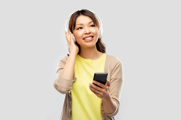 Mujer asiática en auriculares escuchando música — Foto de Stock