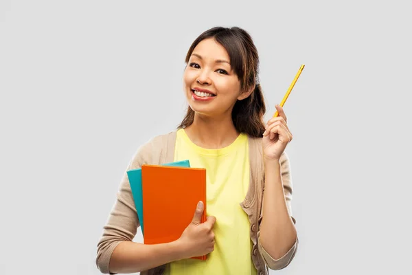 Estudiante asiática mujer con libros y lápiz — Foto de Stock