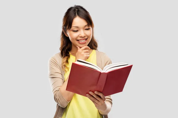행복 한 동양 여성이 책을 읽는 모습 — 스톡 사진