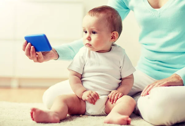 Smartphone προβολή μητέρα με μωρό στο σπίτι — Φωτογραφία Αρχείου