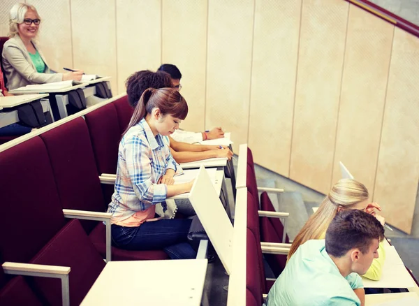 Grupo de alunos com cadernos na sala de aula — Fotografia de Stock