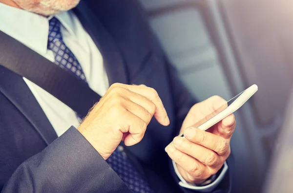 Sénior hombre de negocios mensajes de texto en el teléfono inteligente en coche — Foto de Stock