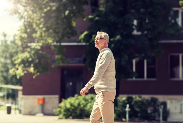 Äldre man går längs sommar stad gata — Stockfoto