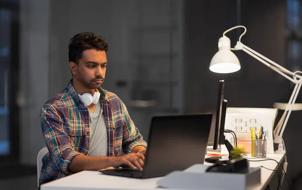 Hombre creativo con el ordenador portátil que trabaja en la oficina de noche — Foto de Stock