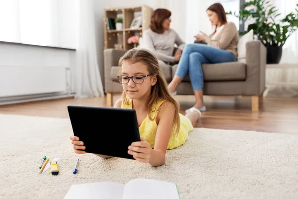 Flicka med Tablet dator liggande på golvet hemma — Stockfoto