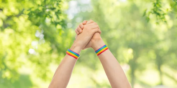 Mãos com orgulho gay pulseiras em ganhar gesto — Fotografia de Stock