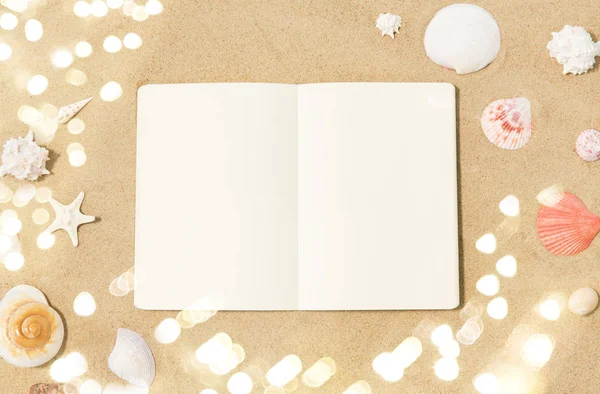 Notebook with seashells on beach sand — Stock Photo, Image