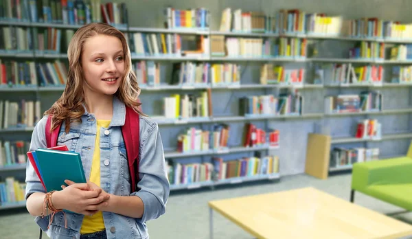 Adolescente menina estudante com livros na biblioteca da escola — Fotografia de Stock