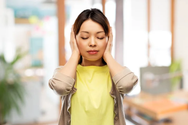 Asiatisk kvinna stänga öronen med händerna — Stockfoto