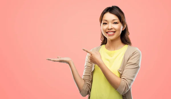 Feliz asiático mulher segurando algo na mão — Fotografia de Stock