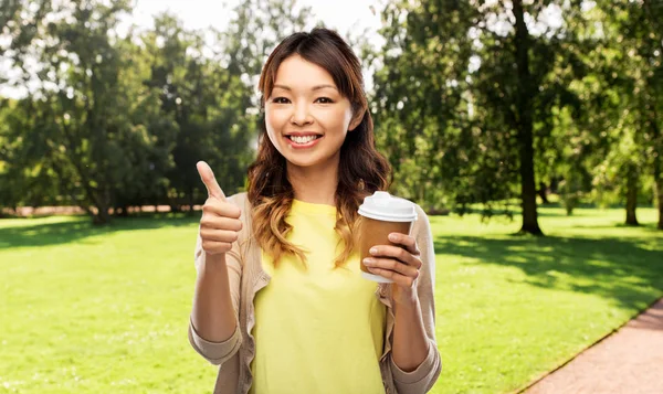 Asian woman drinking coffee and showing thumbs up — Stock Photo, Image