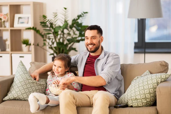 Lycklig far och dotter titta på tv hemma — Stockfoto