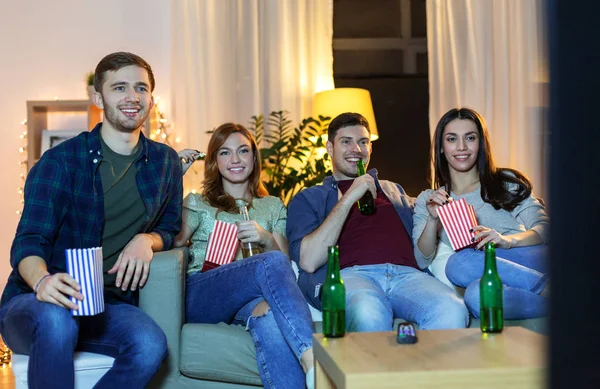 Amigos com cerveja e pipocas assistindo tv em casa — Fotografia de Stock