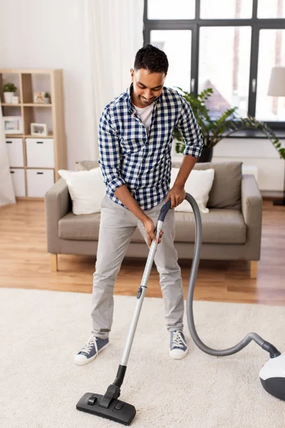 Pria indian dengan vacuum cleaner di rumah — Stok Foto