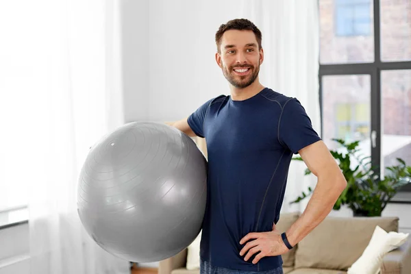 Homem exercitando com bola de fitness em casa — Fotografia de Stock