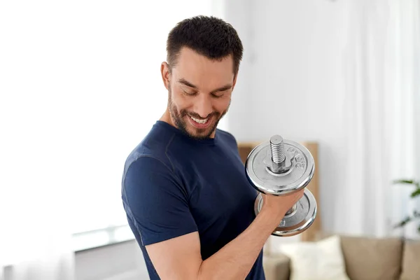 Man exercising with dumbbell at home — Stock Photo, Image