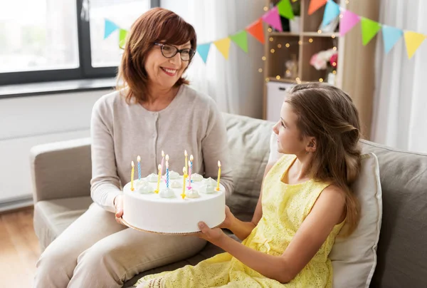 Grootmoeder en kleindochter met verjaardagstaart — Stockfoto