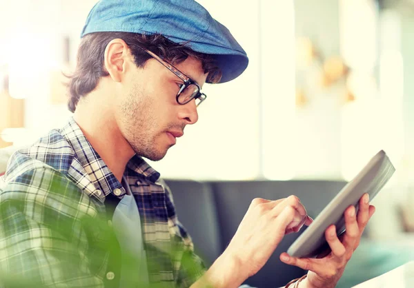 Man met tablet pc zitten aan Cafe tafel — Stockfoto