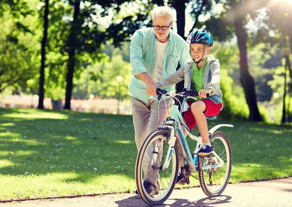 Дедушка и мальчик с велосипедом в летнем парке — стоковое фото