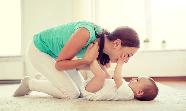 Gelukkig moeder spelen met baby thuis — Stockfoto