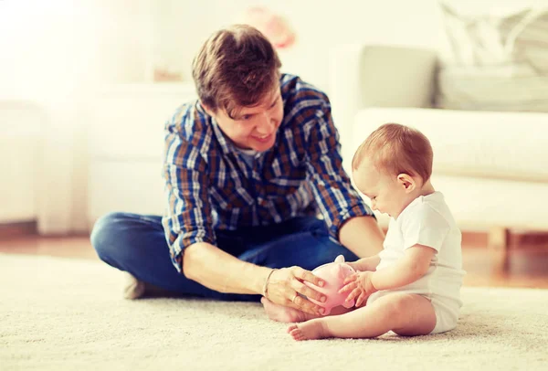 Счастливый отец с ребенком и поросячьим банком дома — стоковое фото