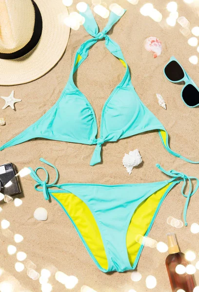 Bikini, chapeau, caméra et lunettes de soleil sur sable de plage — Photo