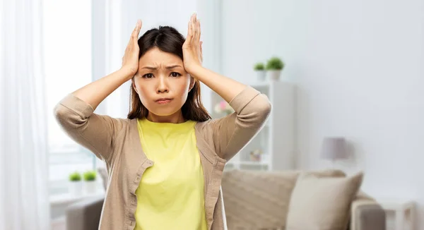 Estresado asiático mujer holding a su cabeza en casa — Foto de Stock