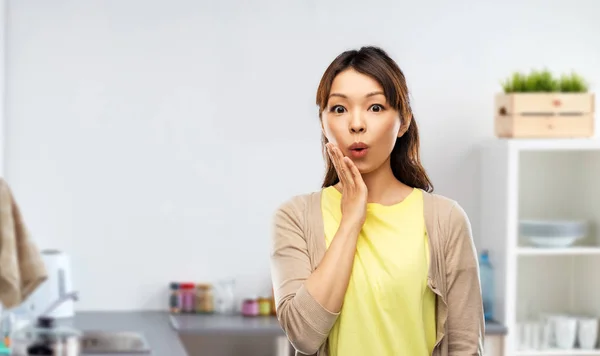 Förvånad asiatisk kvinna över kök bakgrund — Stockfoto