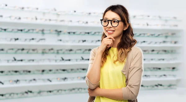 快乐的亚洲女人在眼镜超过光学商店 — 图库照片