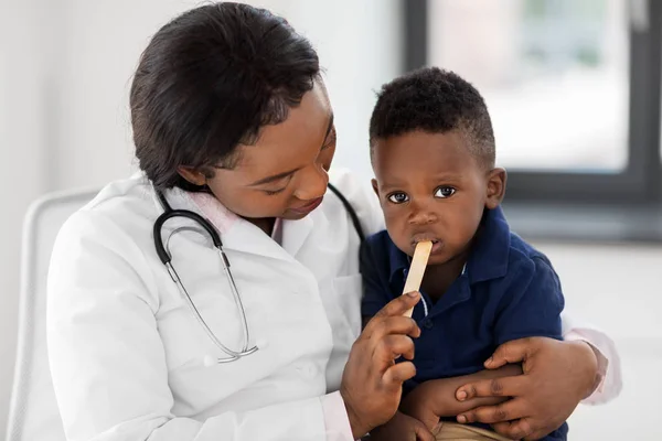 Médico o pediatra con bebé paciente en la clínica — Foto de Stock