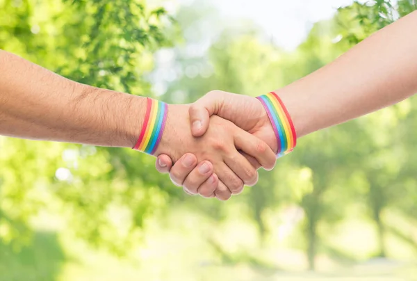 Handen met gay pride-polsbandjes maken handdruk — Stockfoto