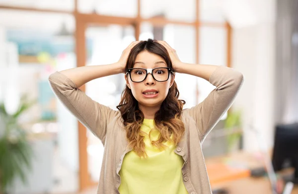 Asiático mujer en gafas holding a cabeza en oficina — Foto de Stock