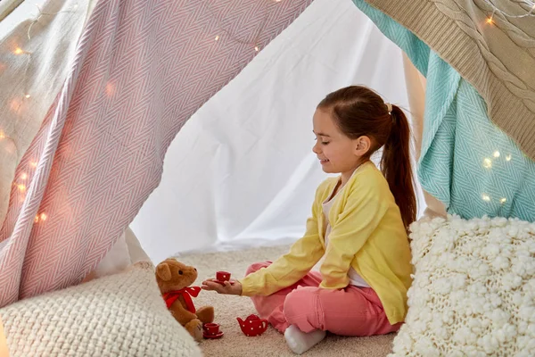 Menina jogando chá festa com pelúcia na tenda crianças — Fotografia de Stock