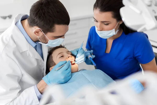 Dentista verificando dentes de criança na clínica odontológica — Fotografia de Stock