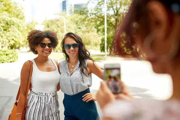 Женщина фотографирует своих друзей в летнем парке — стоковое фото