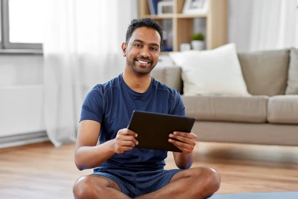 Hombre indio con tableta PC y colchoneta de ejercicio en casa — Foto de Stock