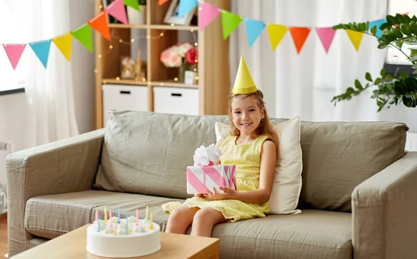 快乐的女孩在党帽与生日礼物在家里 — 图库照片