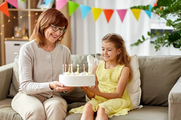 Grootmoeder en kleindochter met verjaardagstaart — Stockfoto